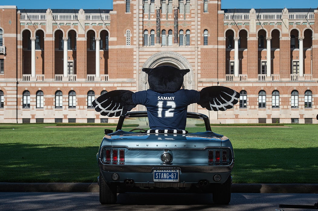 Sammy the Owl sitting in mustang facing Rice campus