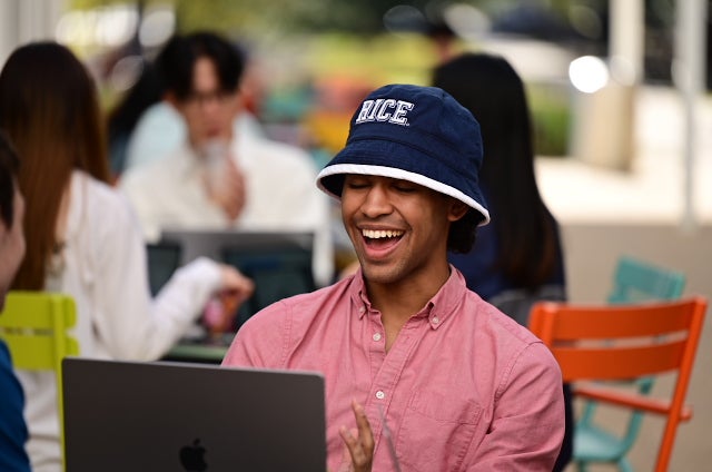 student wearing rice bucket hat laughing